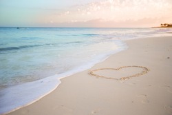 Heart drawn in the sand. Beach background. Top view
