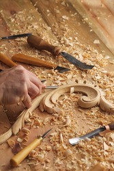 Timber, wood processing. Joinery work. Wood carving with work tools close up. Hand of carver carving wood. Craftsman carving with a gouge