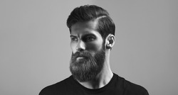 Man portrait. Fashion model with stylish hair and beard. Man with long beard and moustache on serious face Black and white concept photo