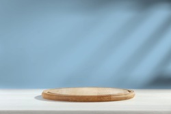 Wooden desk of free space and kitchen board, Blue wall and shadows. 