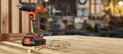 Black and orange drill and wooden desk of free space for your decoration. Workshop interior. 