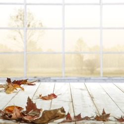 White table background and wondow with autumn leaves 