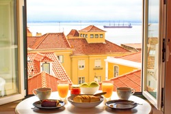 Romantic breakfast by window with a view in Lisbon, Portugal