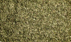 Dry organic Basil Leaves Crushed  top view background or texture. Healthy spices, nuts, seeds and herbal products.