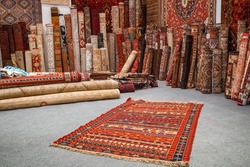 Variety of the gorgeous oriental carpets in traditional carpet store in Middle East. Pile of beautiful handmade carpets on the traditional Middle East market bazaar. Colourful carpets close-up