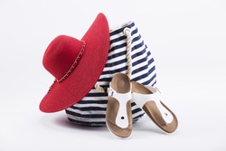 Bright beach accessorize. Red hat and navy bag.