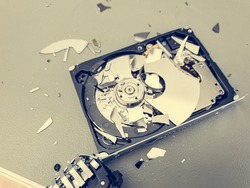 Broken computer hard disk on a table - complete data destruction.