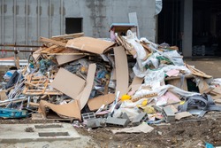 Pile of construction waste in front of an unfinished building.