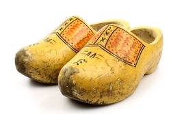 pair of traditional Dutch yellow wooden shoes isolated on a white background