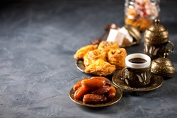 Eid mubarak with arabic coffee pot and dates. Dried dates and coffee on a dark background. Ramadan, Eid concept