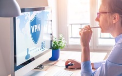 VPN secure connection for freelancer Person using Virtual Private Network technology on computer to create encrypted tunnel to remote server on internet to protect data privacy, home office.