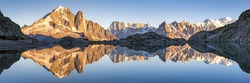 Beautiful panorama of Alps mountain range with sunset lights and reflection in an altitude lake near Chamonix, France. View of White Mount, highest peak in Europe
