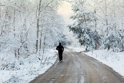 Man running in the winter forest covered with snow.