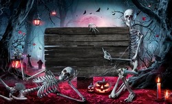Halloween Card In Forest With Wooden Sign Board - Graveyard At Night With Pumpkins And Skeletons