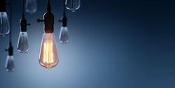 Innovation And Leadership Concept - Glowing Bulb On Among Bulbs Off
