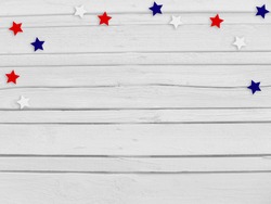 Confetti stars on wooden background. 4th July, Independence day, card, invitation in usa flag colors. Top view, empty space.