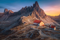 Famous Rifugio Locatelli alpine hut and cute small chapel with spectacular Monte Paterno peaks in background at sunset, Dolomites, Italy, Europe