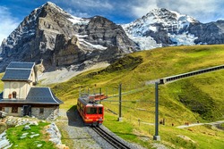 Famous electric red tourist train coming down from the Jungfraujoch station(top of Europe) in Kleine Scheidegg,Bernese Oberland,Switzerland,Europe