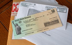 A stack of mail holds an important check from the united states treasury, a check for covid relief during this pandemic