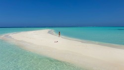 Girl running on a white sandy beach. On the white sandy beach of Bora Bora island, Maldives, Tahiti.