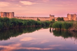 Scenic sunset view of the ancient city wall of the Aigues-Mortes, famous medieval fortress in South France, Camargue national park