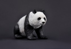 Panda bear plastic toy stock images. Giant panda cute figurine isolated on a black background. Sitting panda bear figurine stock images