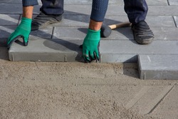 Brick Paver Working. Worker lay paving tiles, construction of brick pavement. Architecture background
