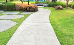Walkway and bush. That is concrete pavement, floor, passage, path, footpath, pathway or passageway with nature for walking along and connecting different section of a building, park or garden.
