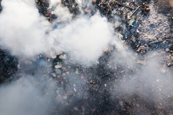 Garbage and fire burn in landfill. Also call trash, waste, rubbish. Destruction with combustion, heat, flame. Occurs smoke, toxic cause of air pollution, environmental damage and global warming.