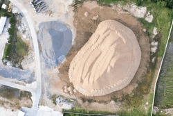 Pile of sand and rock or gravel in site, concrete plant in top view. Heap of aggregate or material from nature, mine or quarry for ready mix of cement, concrete. Builder using in construction industry
