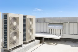 Air compressor or air condenser unit located on roof deck building to heat released transferred to surrounding environment, Compressor is part of cooling function and air conditioning HVAC systems.