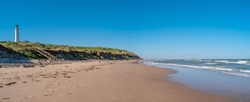 Panoramic view over seashore, beach and lighthouse in Hirtshals, Denmark, summer, at blue sky and sunny day