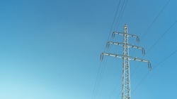 Modern high voltage electrical power towers and wire lines in Germany, in the blue sky and sunset colors and copy space. Concept of energy supply and energy crisis