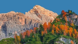 Magical Dolomite peaks at the national park Three Peaks, Tre Cime, in Autumn colors during sunset direct sunlight at blue sky, South Tyrol, Italy, golden season