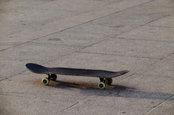 Old used Skateboard is standing on asphalt with tire tracks, Sofia, Bulgaria, Europe 