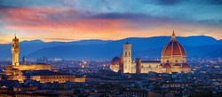 Florence, Tuscany, Italy. Panorama Sunset view at Duomo Santa Maria del Fiore cathedral and Palazzo Vecchio Tower. Panoramic View of Firenze during sunset. Scenic landscape mountains evening sky.