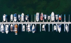 Aerial view of a lot of white boats and yachts moored in marina. Photo made by drone from above. Summer, Norway, Sognefjord, village Vik.