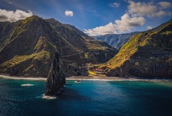 View of the Ilheus da Ribeira da Janela rock islets under a clear blue sky. The rocks form a famous landmark on the northern shore of the island of Madeira, Portugal. Aerial drone shot, october 2021