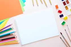 School stationery on pink paper. Colored pencils, pens, pains, paper, brushes for school and student education. Back to school. Copy space. Top view. Flat lay