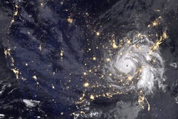 Huge hurricane over America, night photography. Lights of night cities and the eyes of the hurricane are clearly visible. Collage with abstract hurricane. Elements of this image furnished by NASA.