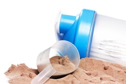 Closeup of shaker, scoop and chocolate whey protein or mass gainer powder