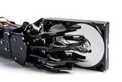 Real robotic hand with Hard disk drive. Concepts of AI-powered data protection or machine learning.