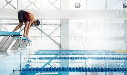 Professional woman swimmer in a starting position 
