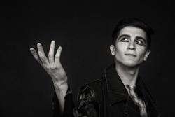 Professional game young actor. Black and white photo on a dark background. Professional makeup and theatrical image. Photo for cultural and fashion magazines and websites.
