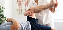 Modern rehabilitation physiotherapy worker with senior client