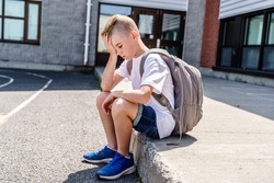 A very sad boy bullying in school playground.