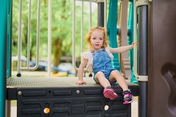 A Child playing on outdoor playground. Active kid on playground summer activity for children