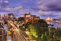 Aerial elevated view of The Rocks historic district in Sydney CBD as Sunset when bright lights illuminate city streets and landmarks.