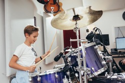 young boy playing drums at the music studio