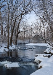 The colors of dusk settle over a secluded stream at the close of a winter day.